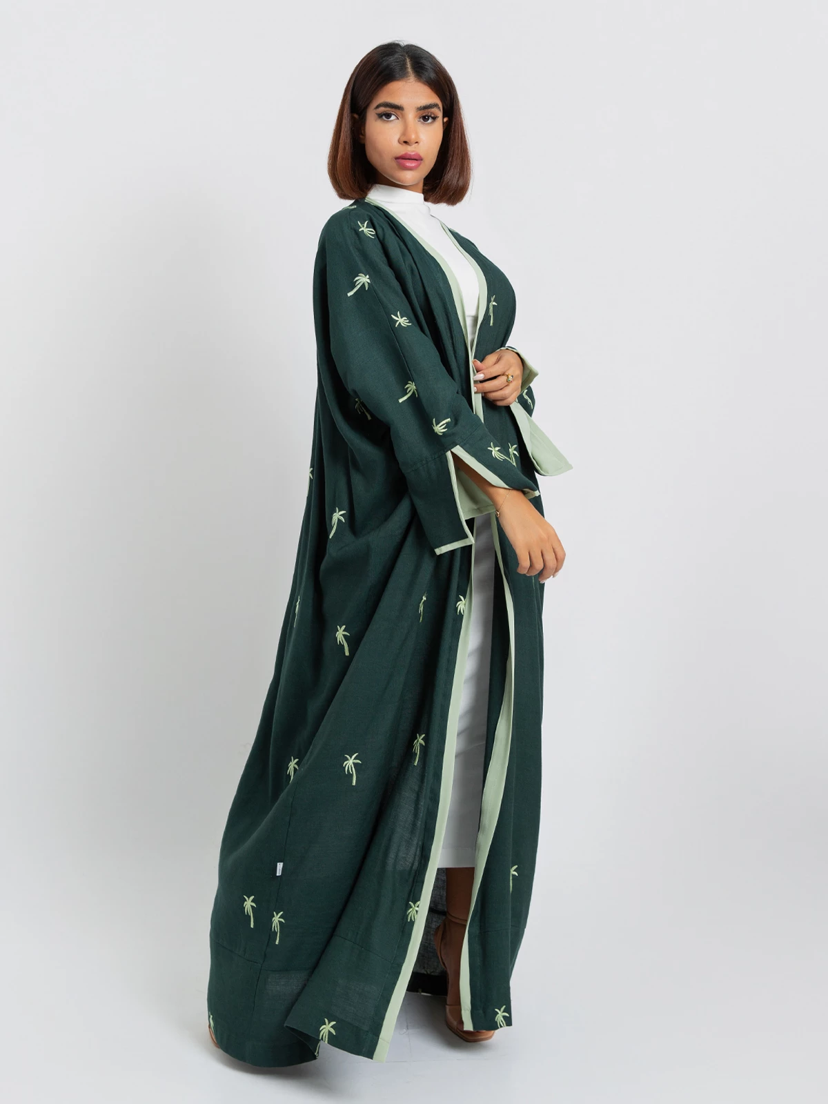 Green open long fancy linen abaya with light green palm trees embroidery in high quality fabric by kaafmeem 